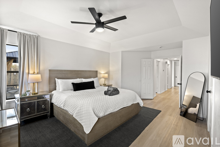 A bedroom with a large bed and a ceiling fan.