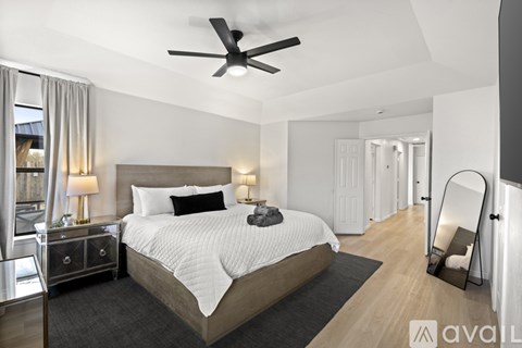 A bedroom with a large bed and a ceiling fan.