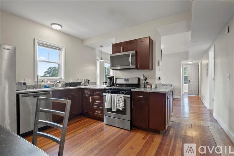 A kitchen with wooden floors and stainless steel appliances.