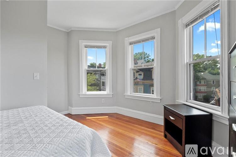 A bedroom with a large bed and two windows.