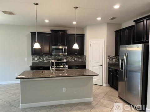 A kitchen with black cabinets and a granite countertop.
