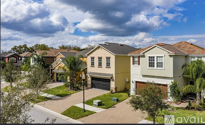 A row of houses with a cloudy sky above them.