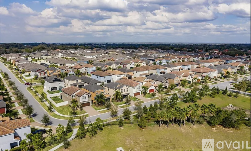 A bird's eye view of a residential neighborhood with houses and palm trees.