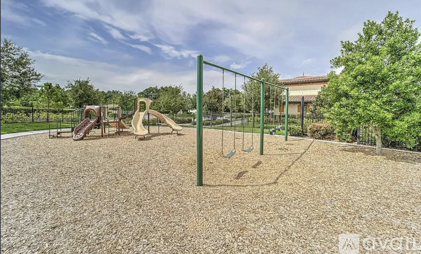A playground with a slide, swings, and a seesaw.