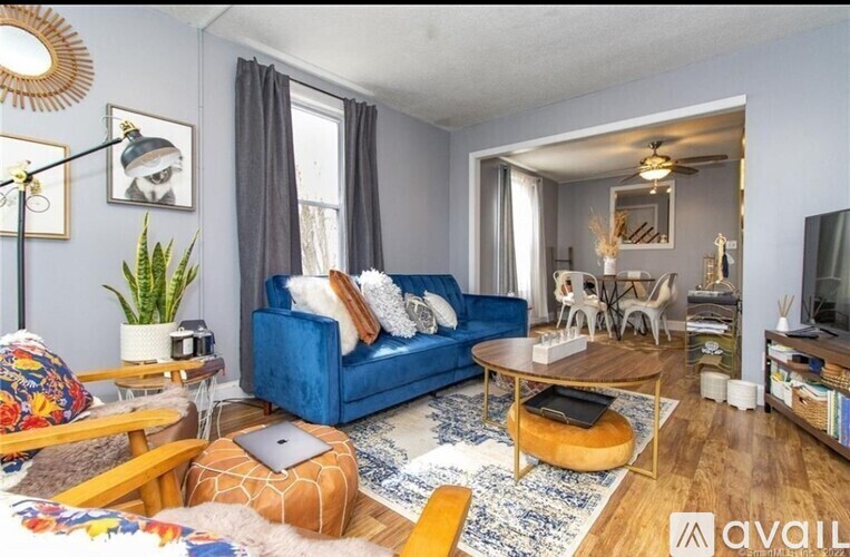 A living room with a blue couch and a wooden coffee table.