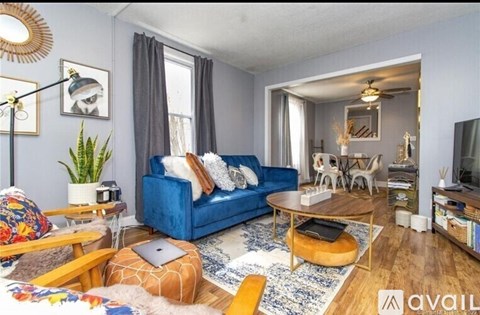 A living room with a blue couch and a wooden coffee table.