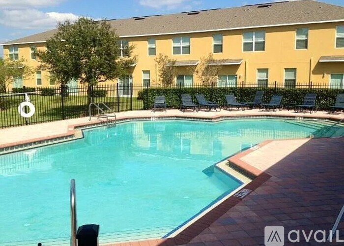 A pool in front of a building with the word Avail on it.