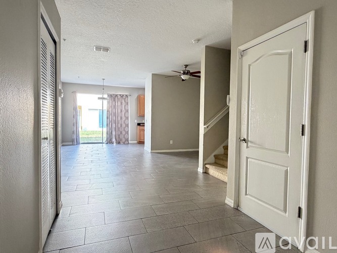 A spacious room with a tiled floor and a ceiling fan.