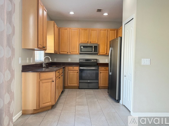 A kitchen with wooden cabinets and a black oven.