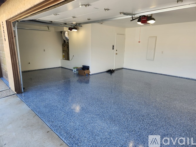 A spacious room with a blue floor and white walls.