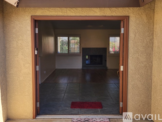 A room with a doorway leading to a living room with a couch and a television.