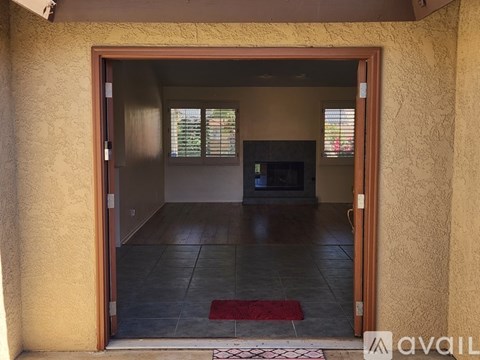 A room with a doorway leading to a living room with a couch and a television.