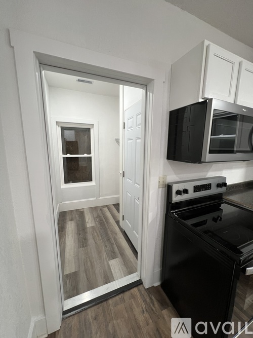 A kitchen with a black stove top oven and white cabinets.