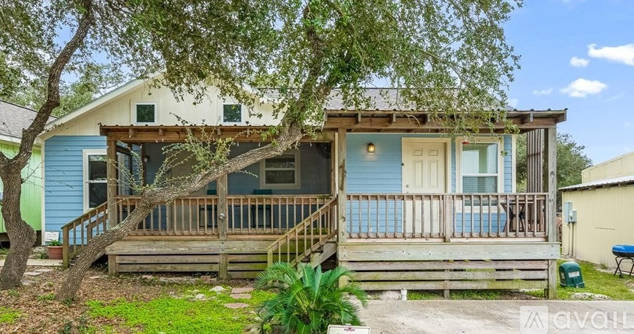 A house with a blue exterior and a wooden deck.