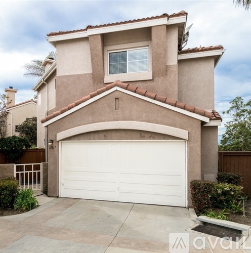 A house with a white garage door and a brown roof.