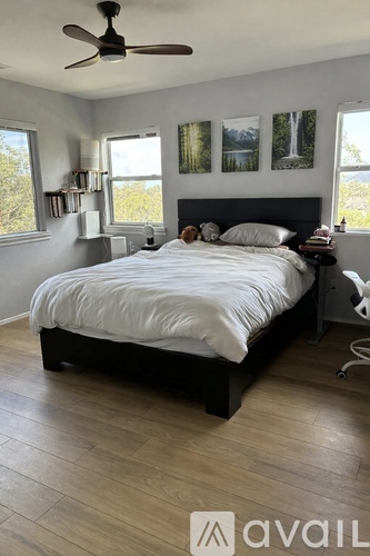 A bedroom with a large bed and a ceiling fan.