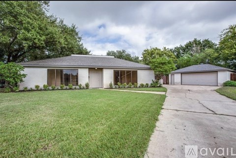 A house with a large front yard and a driveway leading to a garage.