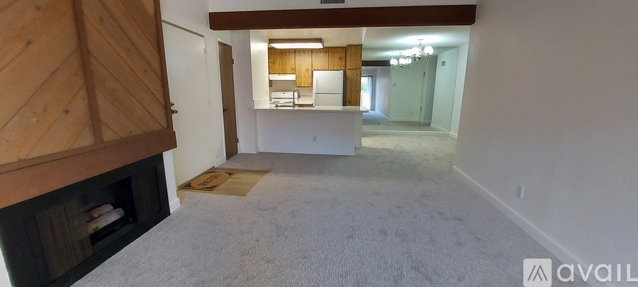 A living room with a fireplace and a rug on the floor.