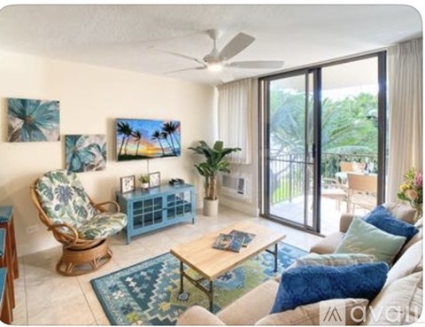 A living room with a blue chair and a painting of a beach scene on the wall.