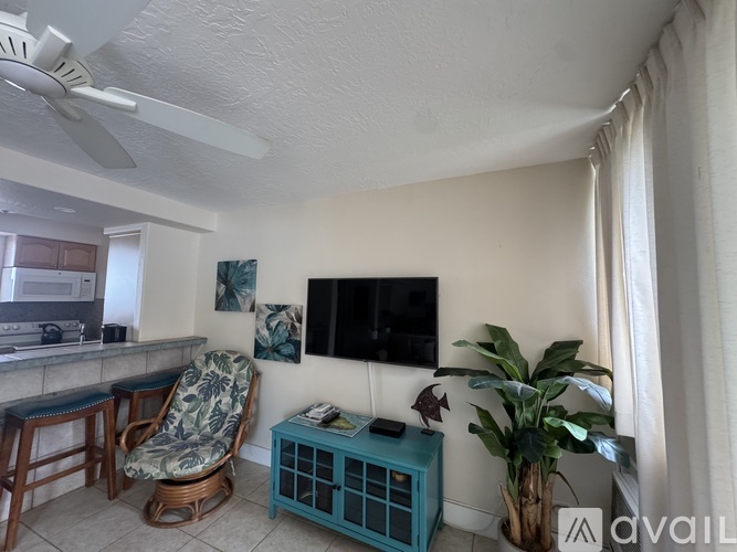 A living room with a blue cabinet and a television mounted on the wall.