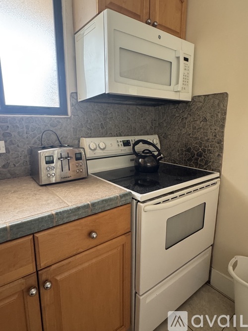 A white microwave oven mounted above a white gas stove in a kitchen.