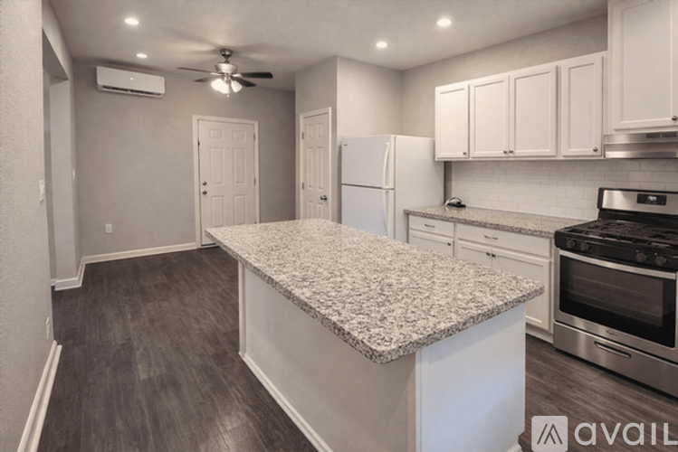 A kitchen with a granite countertop and stainless steel appliances.