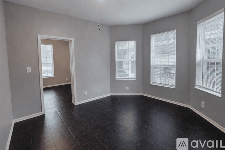 A spacious room with black tiled flooring and a large window.