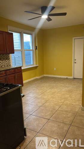 A room with yellow walls and a black fridge.