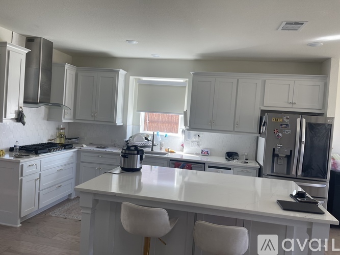 A kitchen with white cabinets and appliances.