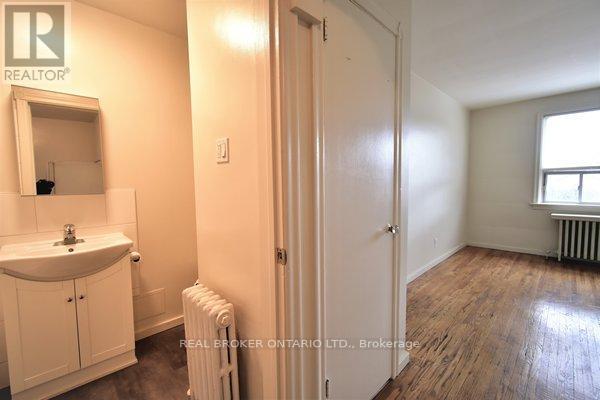A bathroom with a sink, mirror, and a radiator.