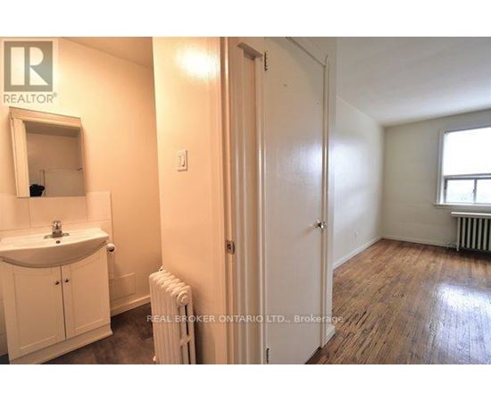 A bathroom with a sink, mirror, and a radiator.