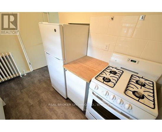 A white stove in a kitchen with a white refrigerator.
