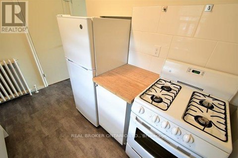 A white stove in a kitchen with a white refrigerator.