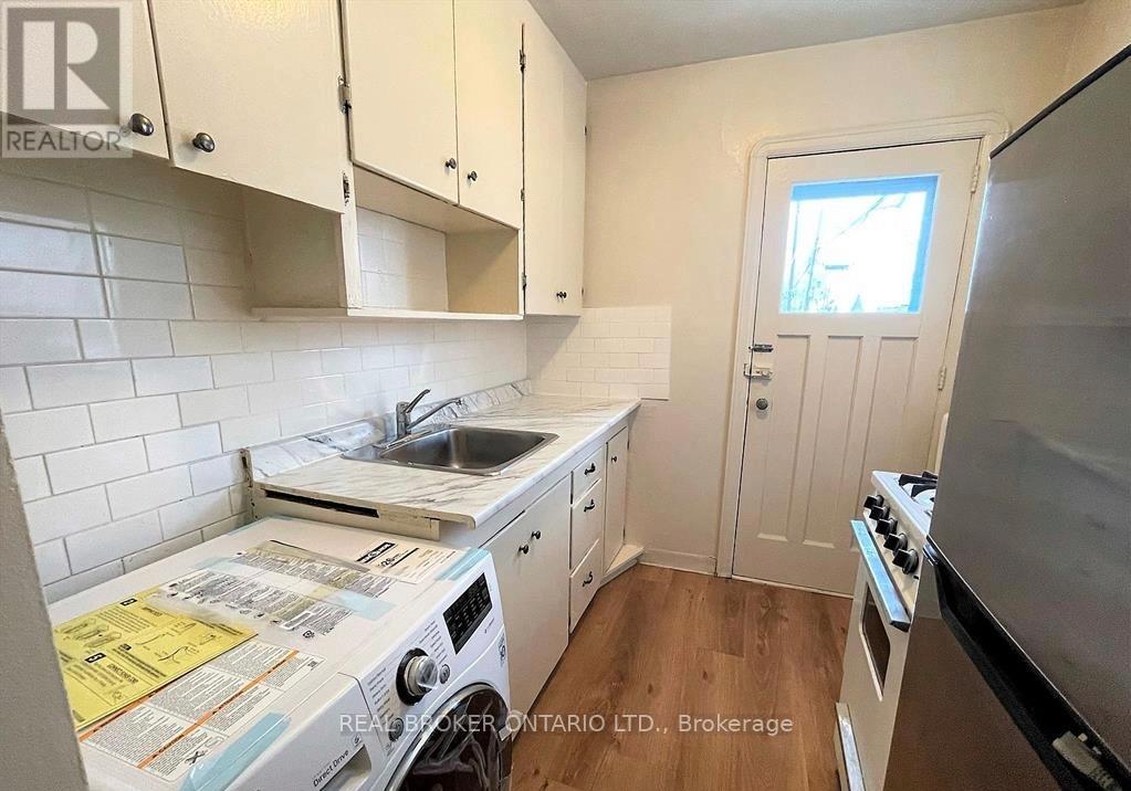 A small kitchen with a washing machine and a stove.