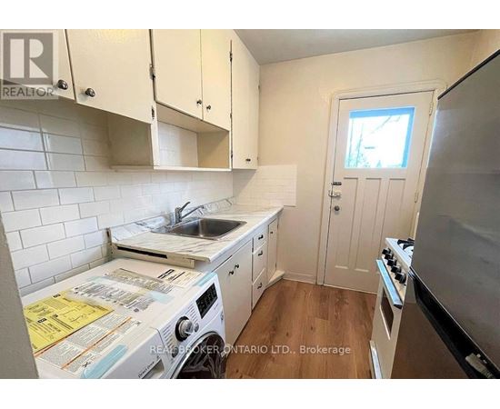 A small kitchen with a washing machine and a stove.