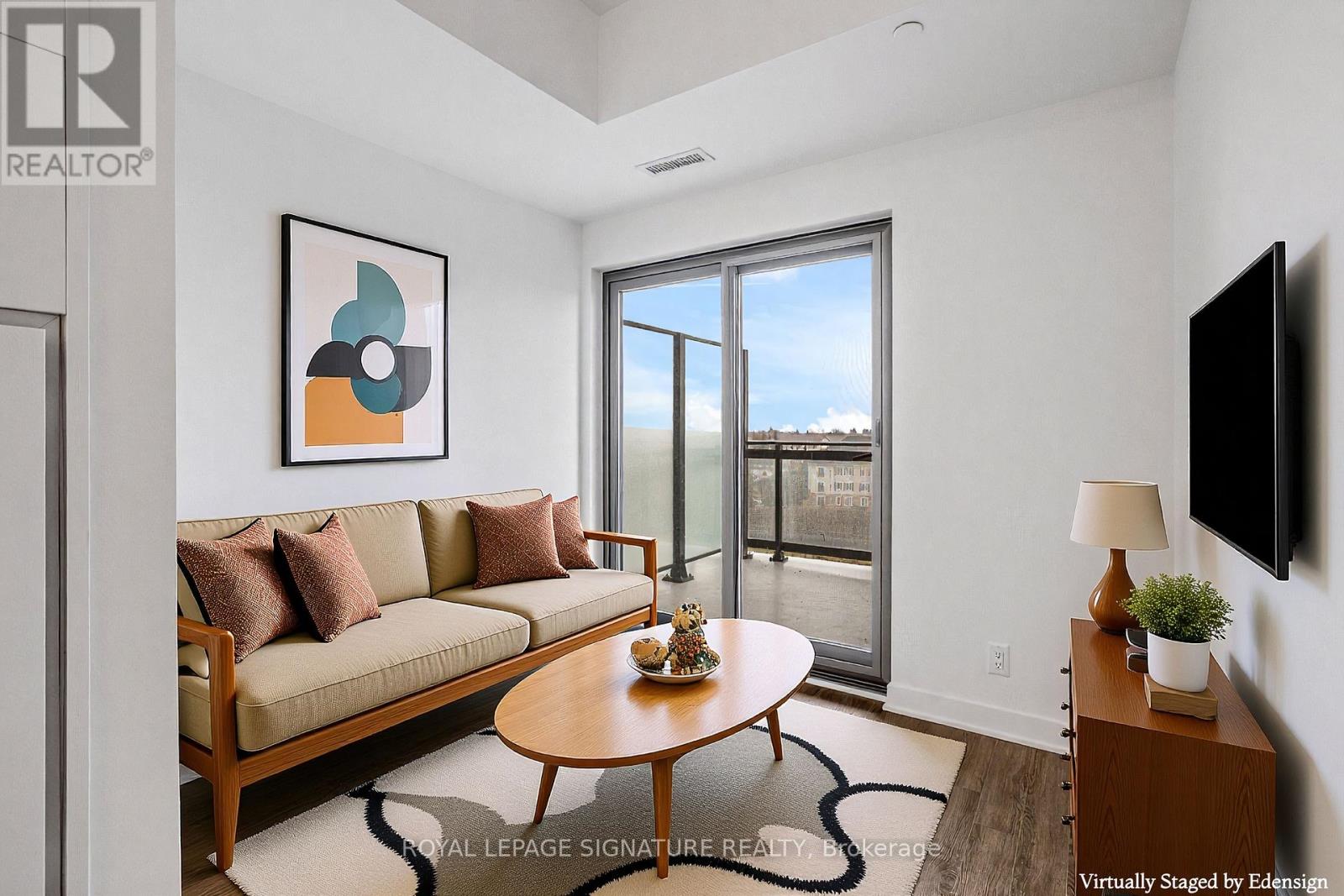 A living room with a couch, coffee table, and a painting on the wall.