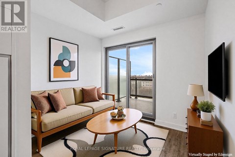 A living room with a couch, coffee table, and a painting on the wall.