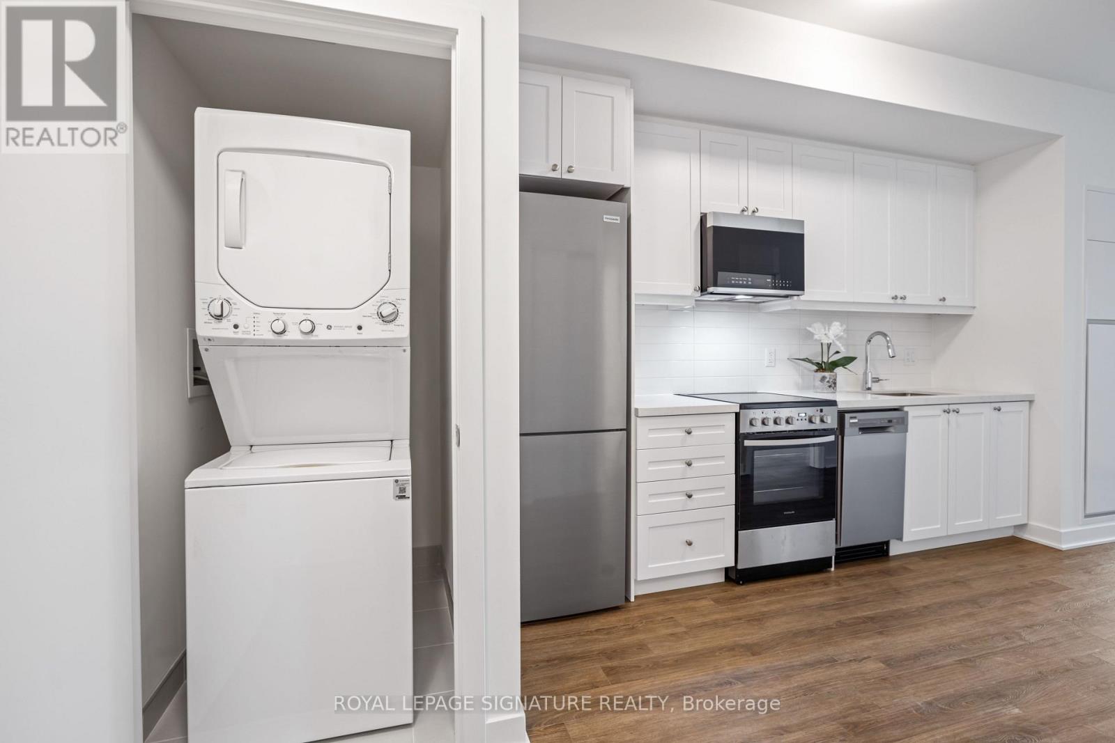 A white kitchen with a refrigerator, oven, and microwave.