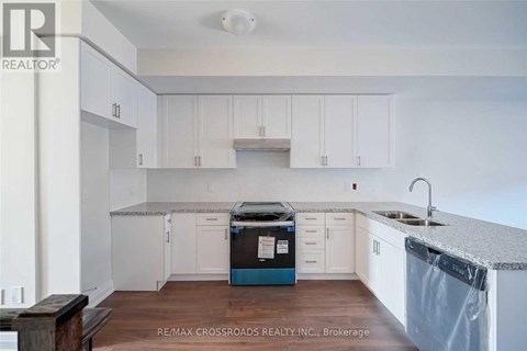 A kitchen with white cabinets and a blue dishwasher.