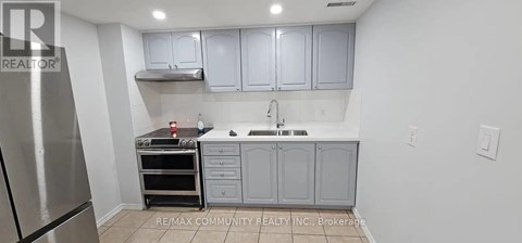 A kitchen with a stainless steel refrigerator and a stove top oven.