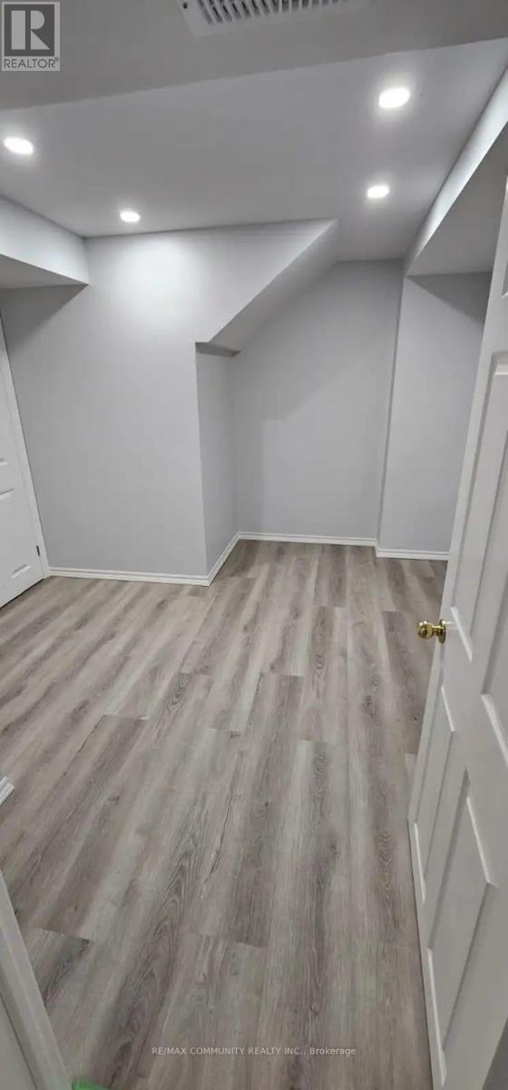 A room with wooden flooring and white walls.