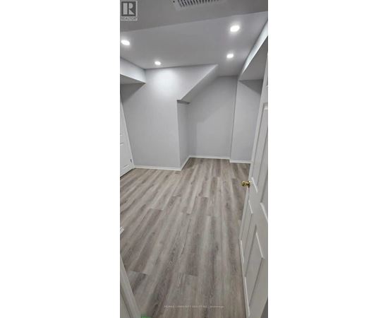 A room with wooden flooring and white walls.