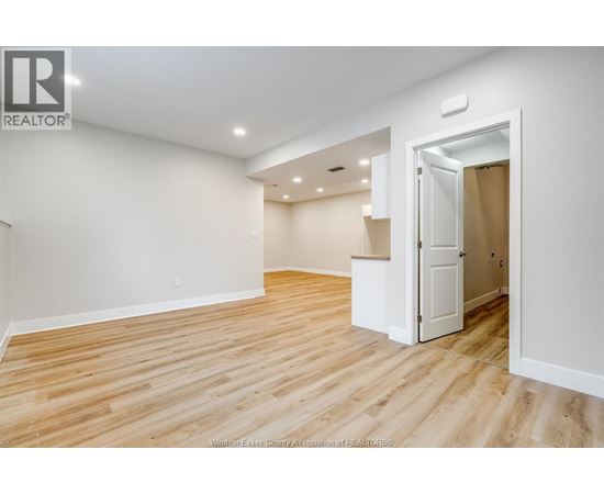 A room with wooden flooring and a white door.
