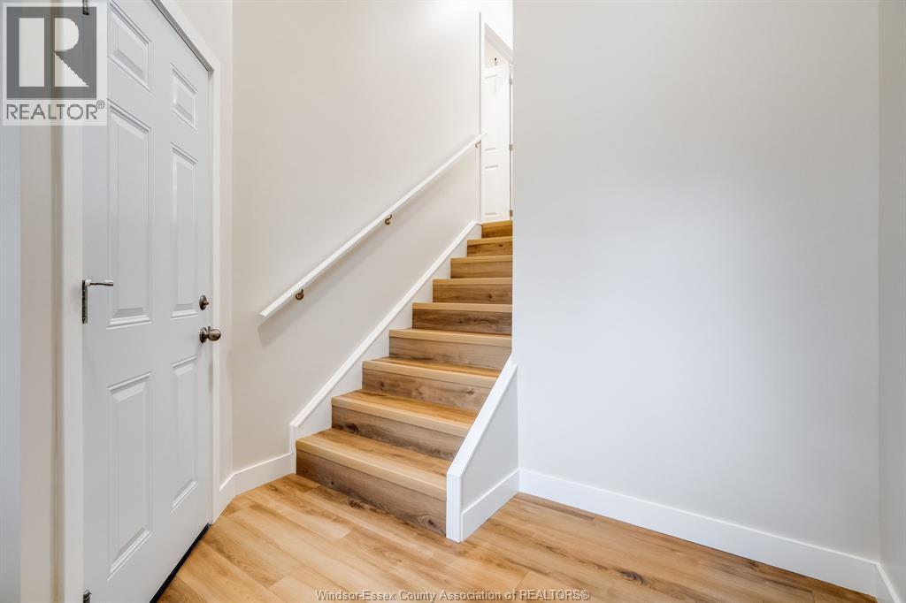 A white door is on the left of a staircase with wooden steps.