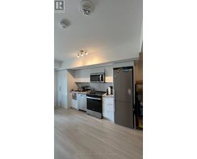 A modern kitchen with a refrigerator, stove, and oven.