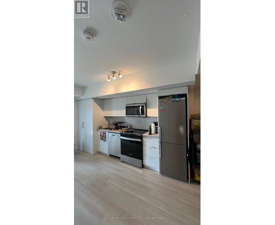 A modern kitchen with a refrigerator, stove, and oven.