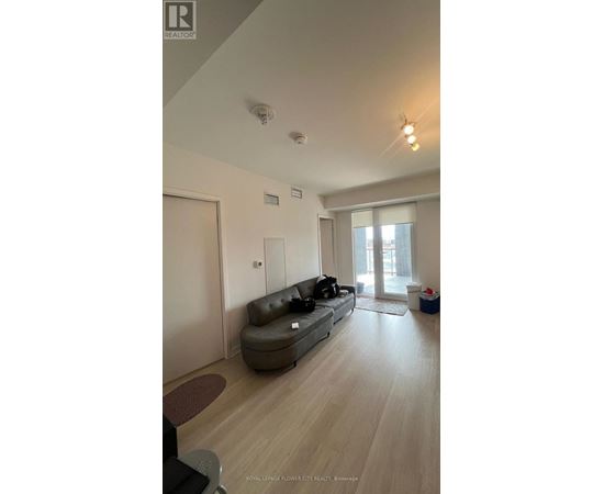 A living room with a grey sofa and wooden flooring.