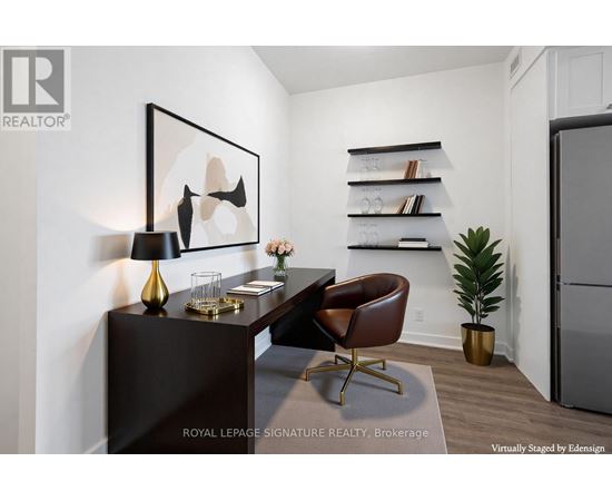 A modern living room with a brown leather chair and a painting on the wall.