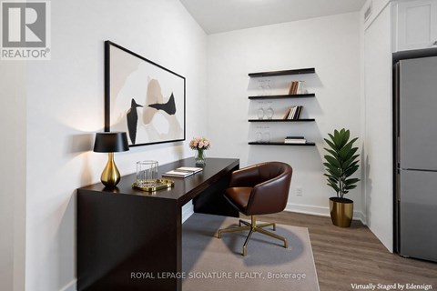 A modern living room with a brown leather chair and a painting on the wall.