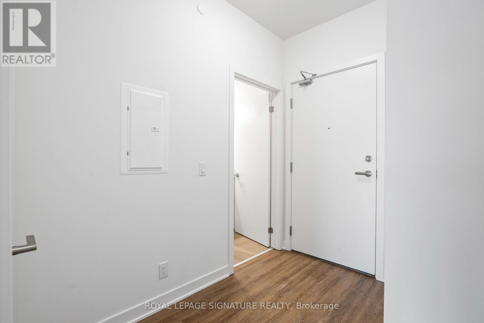A white room with a door on the right and a window on the left.